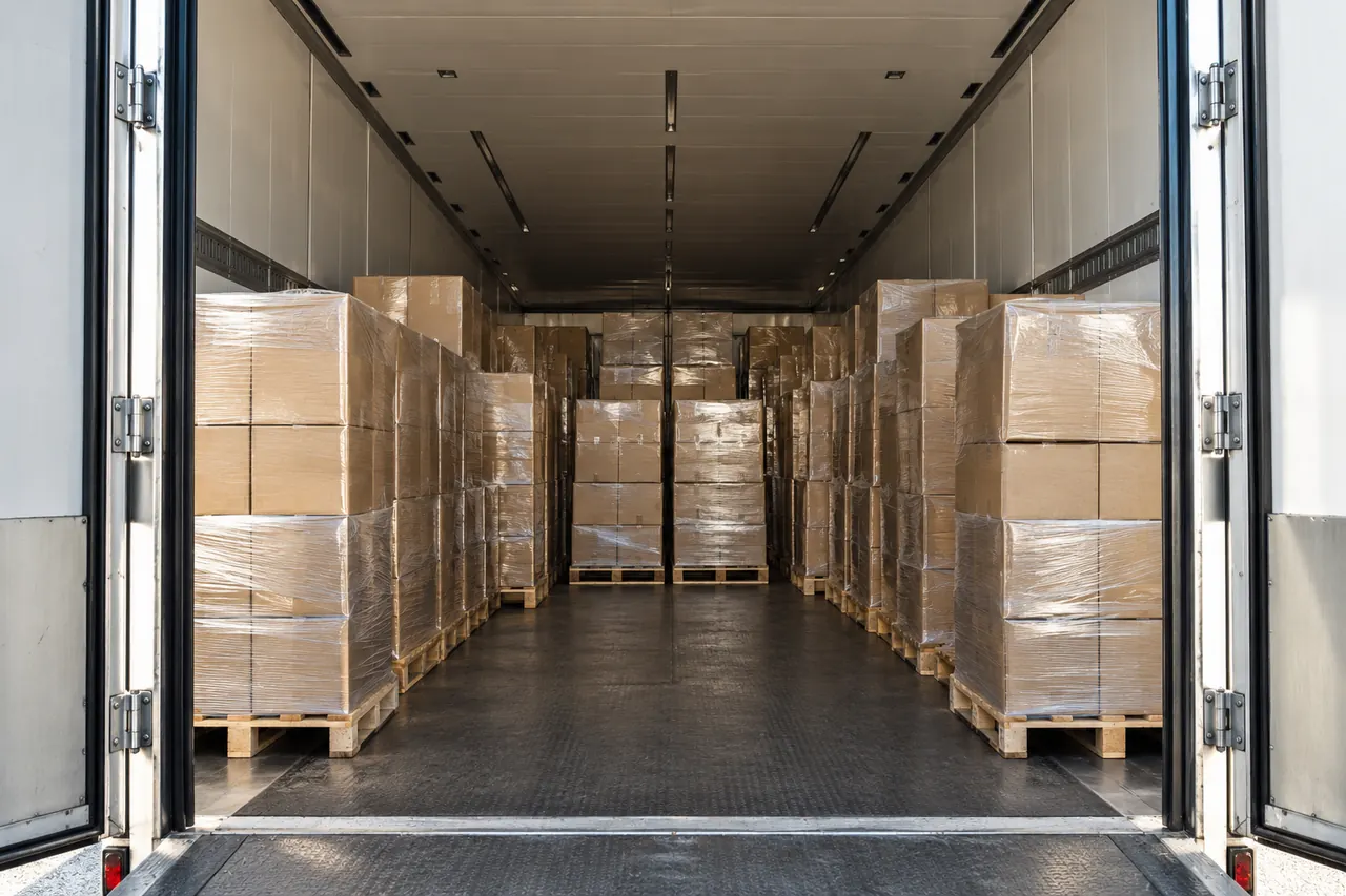 Semirremolque con las puertas abiertas, cargado de palets hasta el fondo.